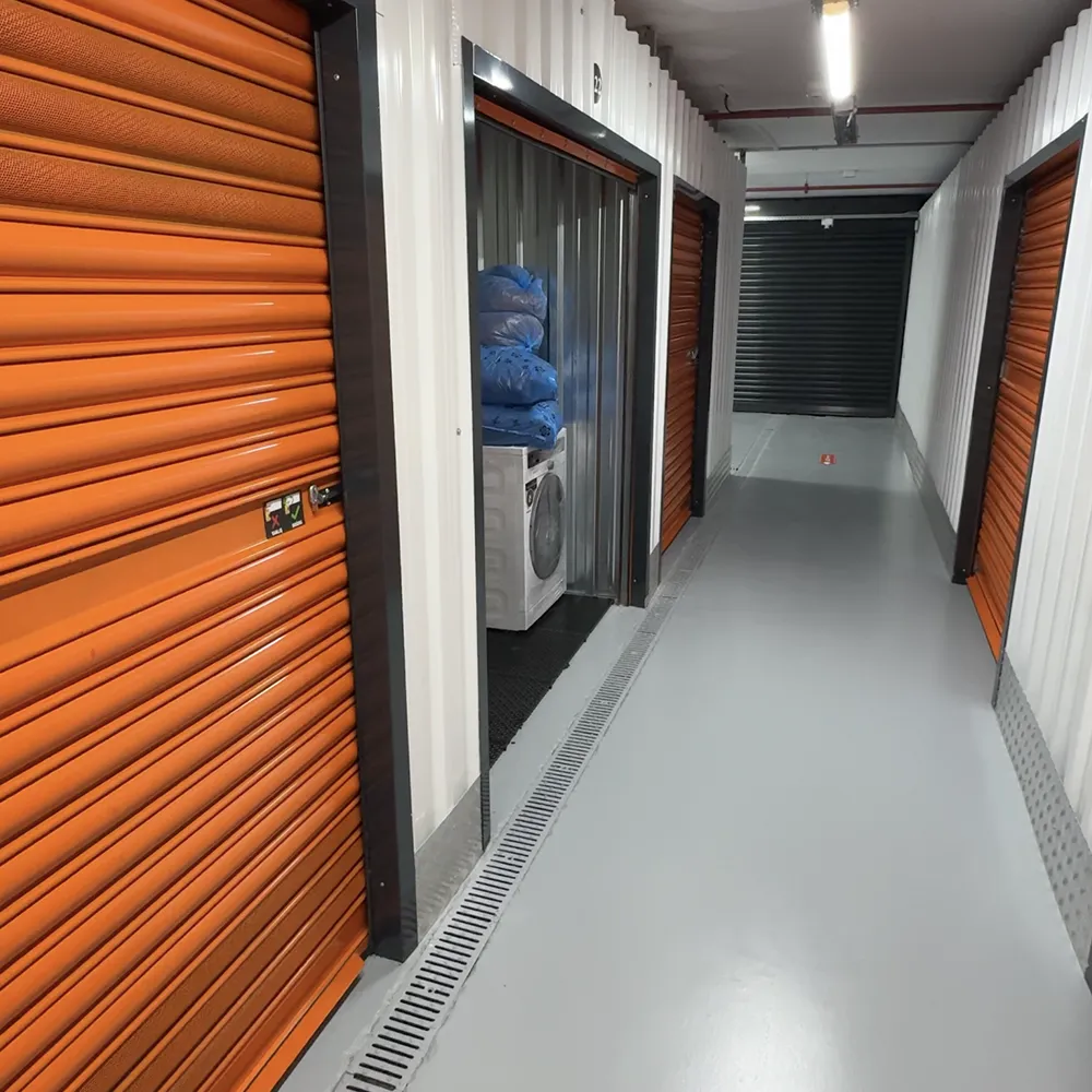 Depo koridorunda turuncu kapılı üniteler ve ortak alan görünümü